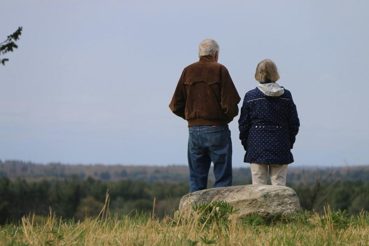 Senior couple standing together looking out over a field