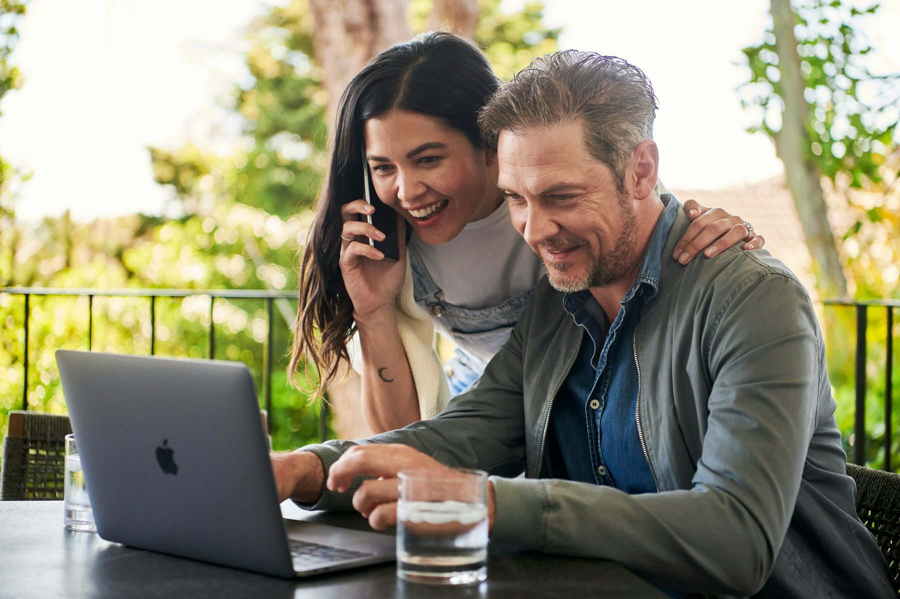Couple reviewing plans together on a laptop outdoors