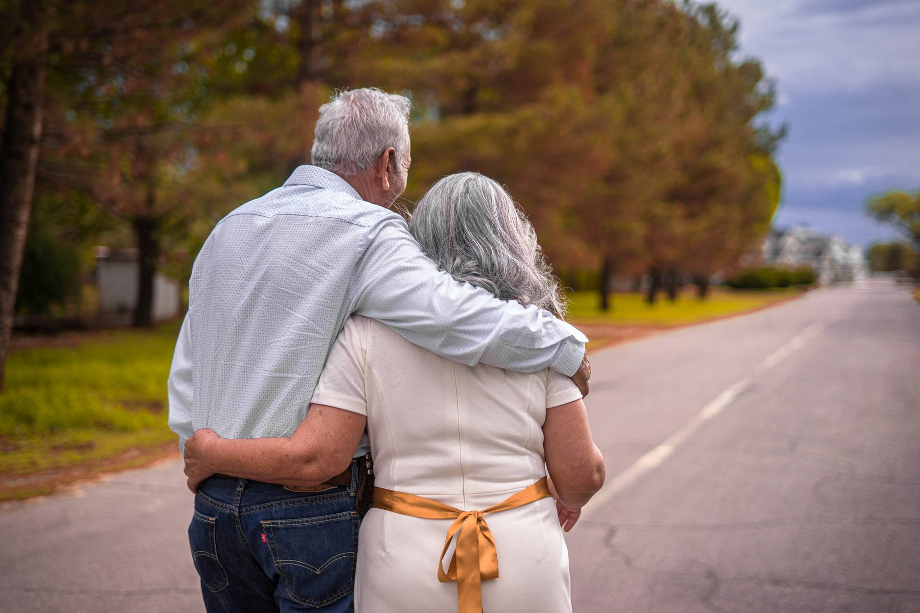 Retired couple walking together, arms around each other