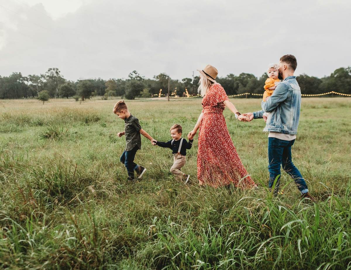 Family walking together holding hands in a field