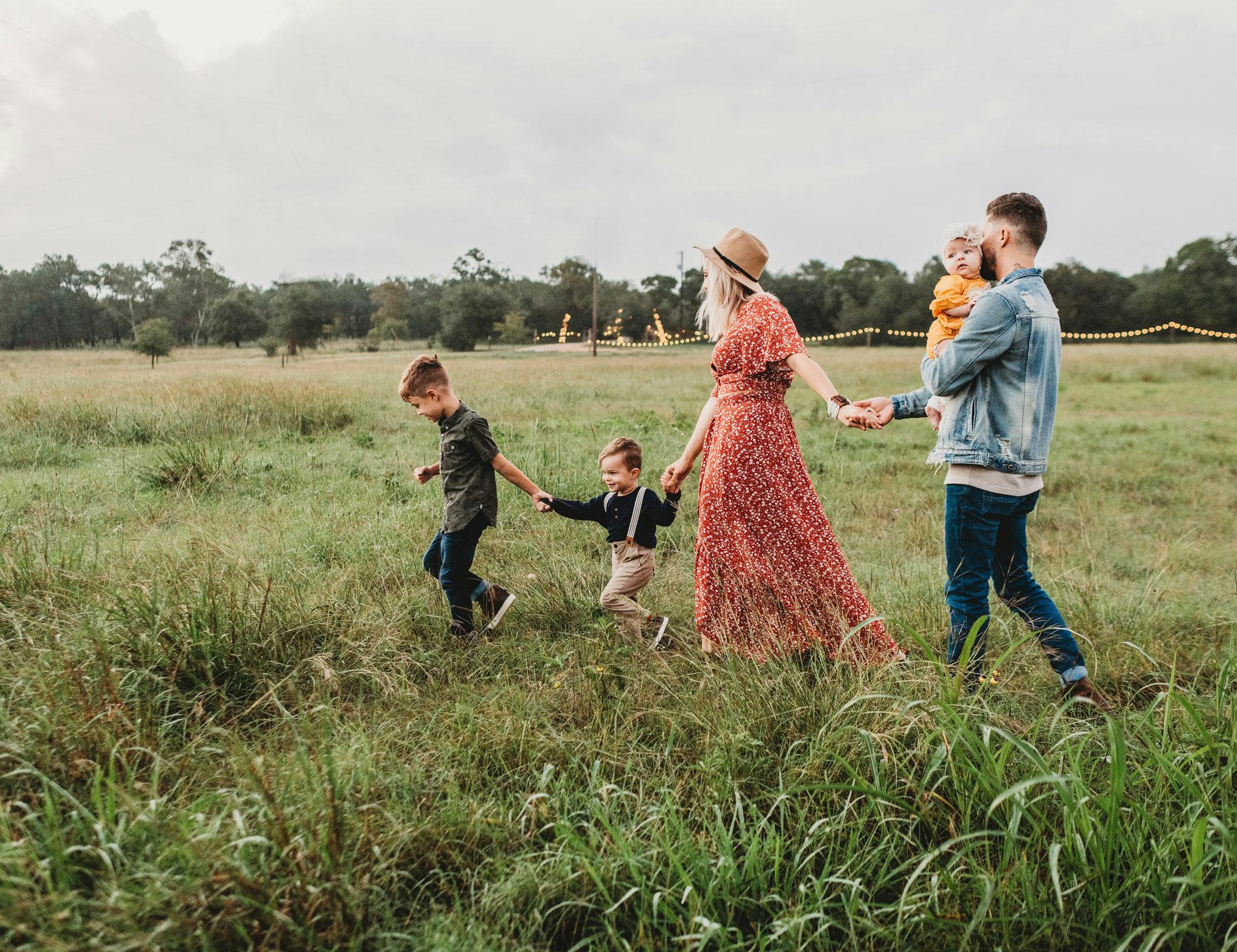 Family walking together holding hands in a field